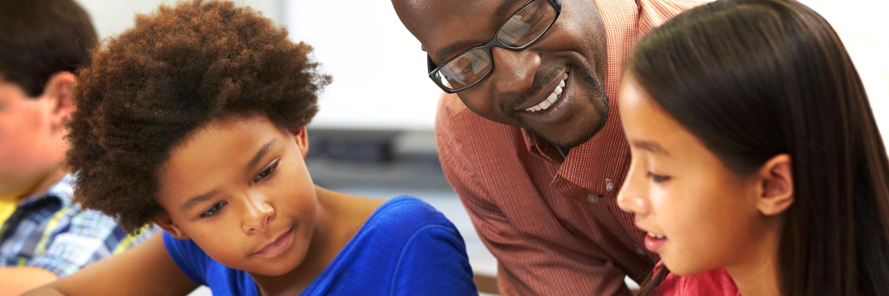 A teacher interacts with two children.