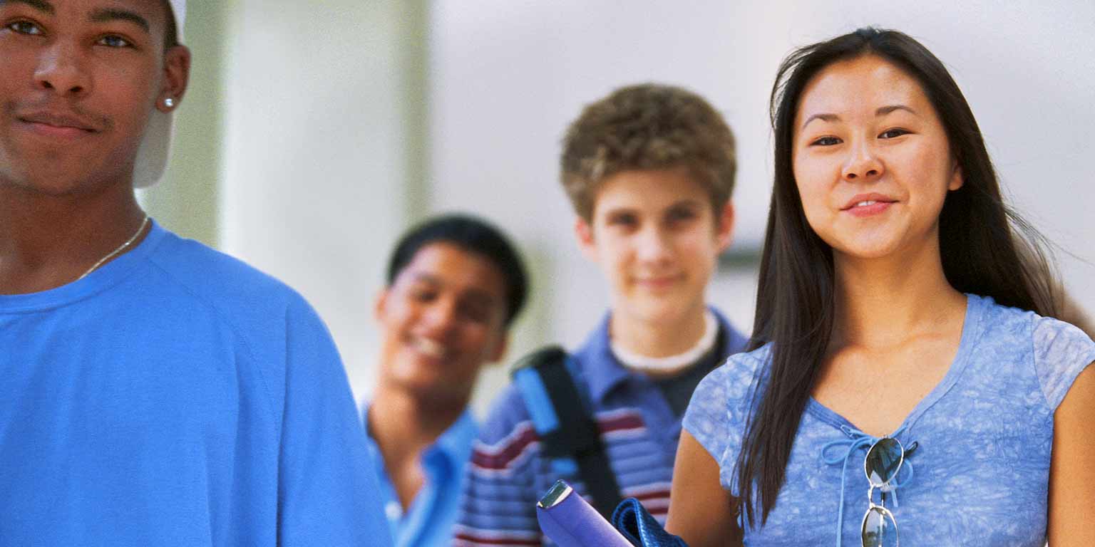 Students walk through a school hallway. 